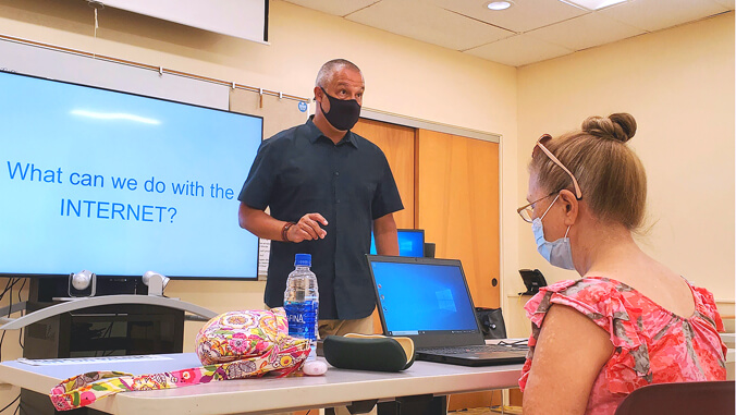 woman in front of the computer, man teaching