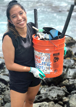 student cleaning beach