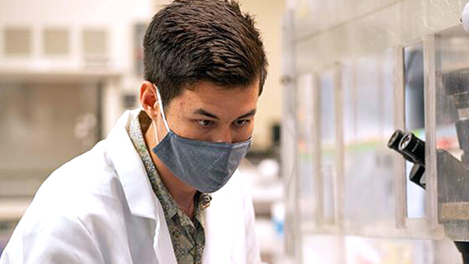 Daniel Woo looking into microscope