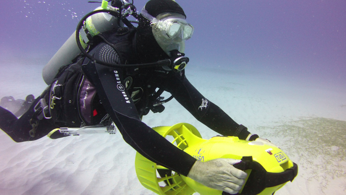 person in scuba gear navigating a robot