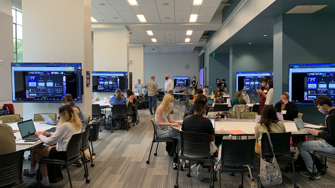 People in groups in front of wall screens