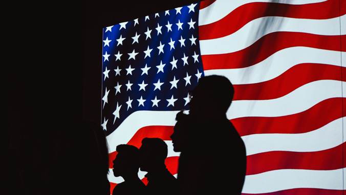 Silhouettes in front of the U S flag
