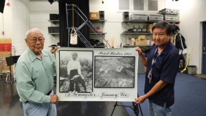 Two men holding a large picture