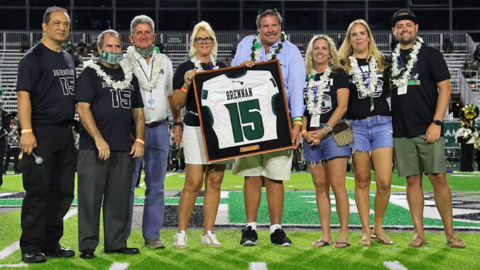 group of people holding Brennan retired jersey