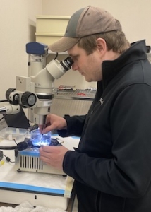 male looking into microscope