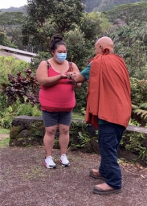 person presenting another person with a small wooden canoe