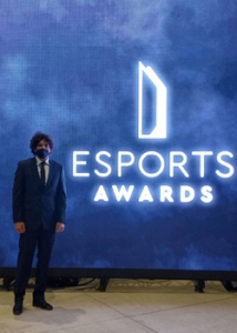 person in suit standing in front of an esports awards sign
