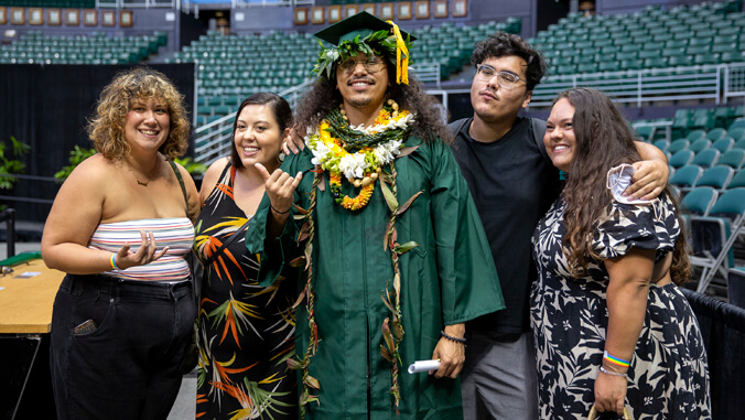 Graduate in cap and gown with family