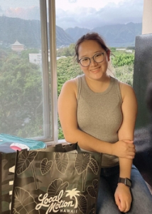 person sitting near a window and smiling
