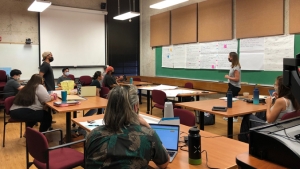 people in a classroom looking at a chalk board