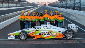 people standing next to a car on a race track