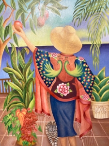 Woman in colorful wrapper reaching for a fruit