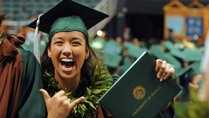 person smiling with a diploma