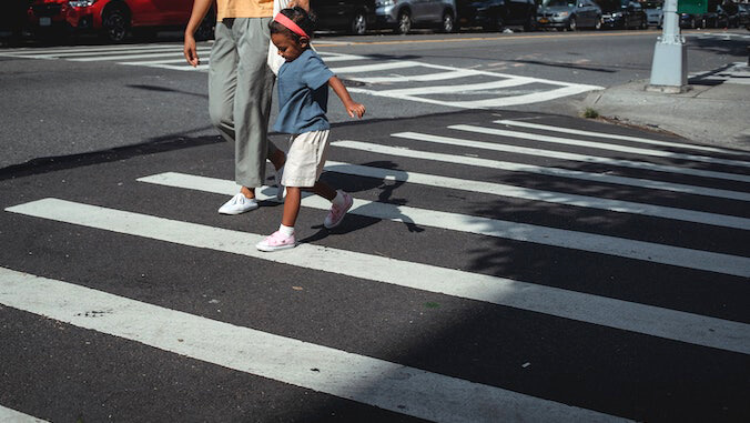 child crossing street with mom