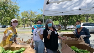 Food drive volunteers in masks flashing shaka