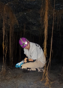 person crouching down in a lava tube