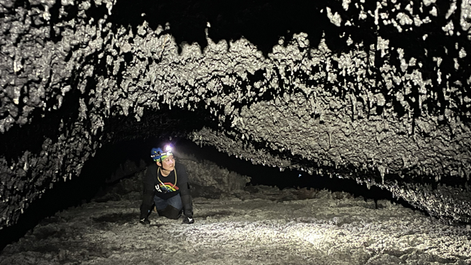 person surrounded by rocks in a lava tube