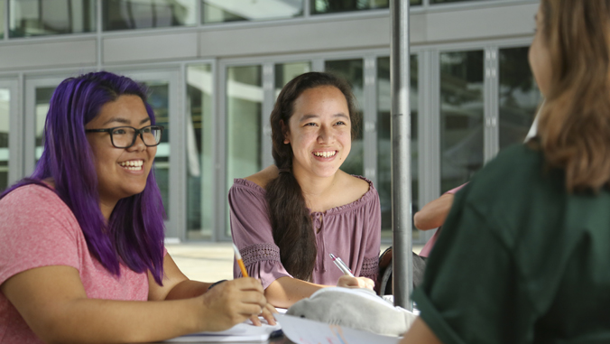 two people smiling while sitting at a table