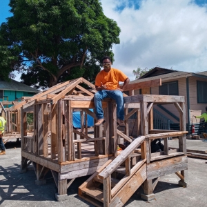 Man sits on a wooden frame construction