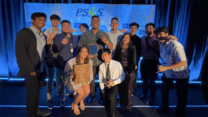 people standing on a stage holding a trophy