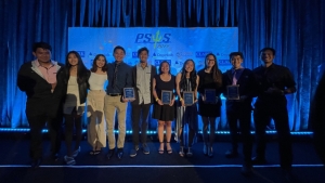 people standing on a stage with a plaque