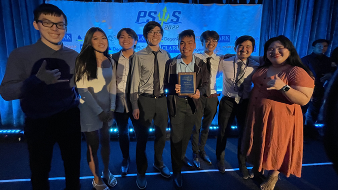 people standing on a stage with a plaque