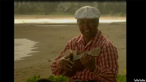 Screenshot of Eddie Kamae smiling with a ukulele