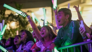 people yelling with green light sticks