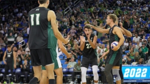 players in jerseys cheering for each other with a volleyball