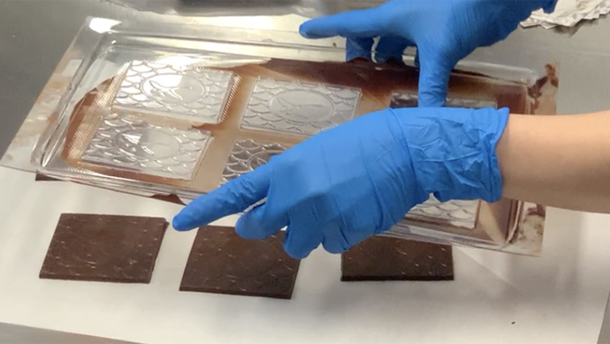 chocolate squares being taken out of their molds