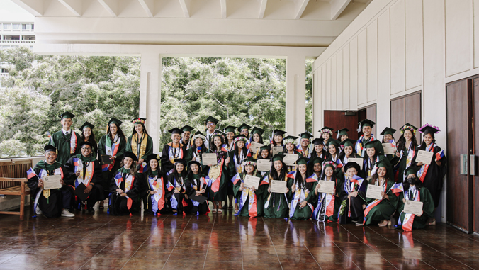 people in caps and gowns smiling at the camera