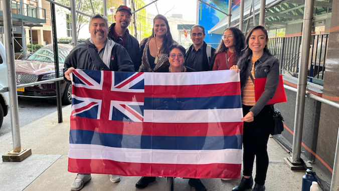 Group of people holding a Hawaiian flag