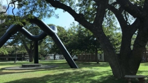 sculpture with bars on grassy lawn