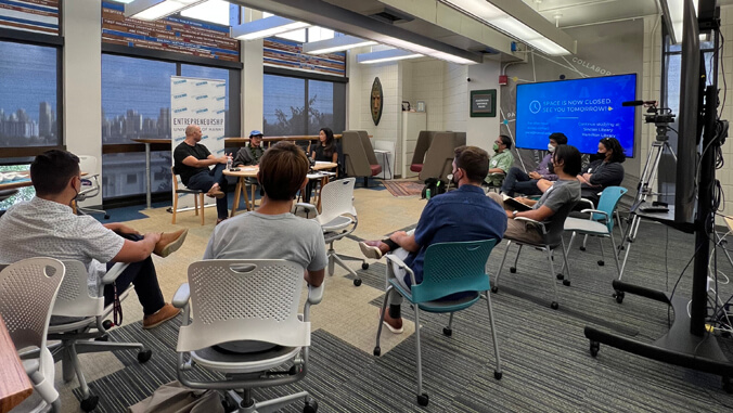 people sitting in chairs looking at three people