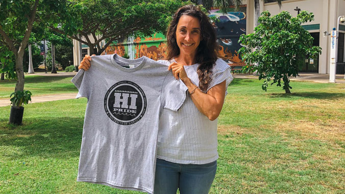 2021 Hi Pride design winner holding a shirt with her logo