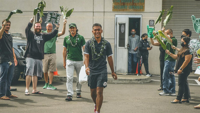 people cheering for person walking with a green shirt