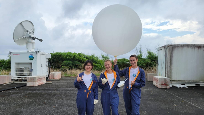 three women holding a weather balloon