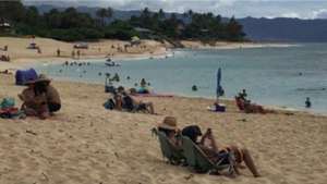 people lounging on the beach near the ocean
