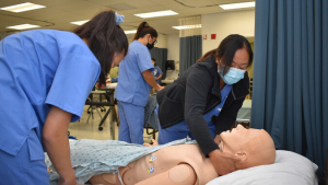 Nursing students working with a simulation dummy