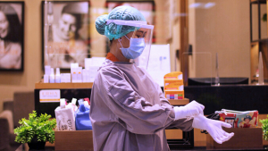Nurse putting on COVID-19 personal protective equipment