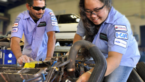 two people working on car engine