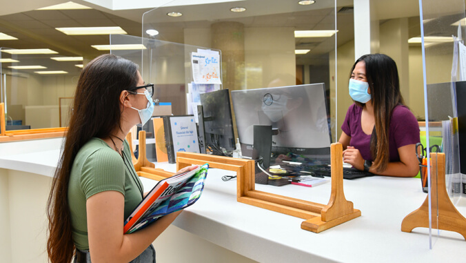 Two people wearing masks inside