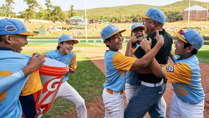 Little league players celebrate with coach