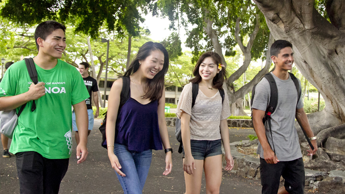 four people walking and smiling