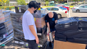 people standing next to pallets of equipment