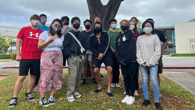 people standing near a tree with masks on