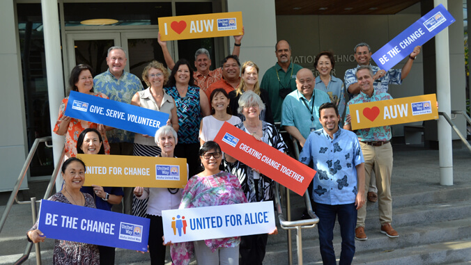 Smiling U H leadership with Aloha United Way signs