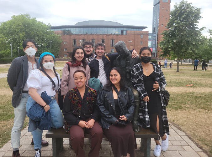 Group of students with a statue of Shakespeare