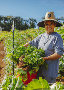 Smiling woman holding a bucket of vegetables