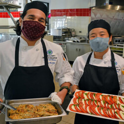 Two students holding plates of food